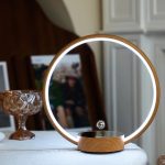 Specchio LED rotondo con base in legno, perfetto come lampada da tavolo decorativa e funzionale. Ideale per ambienti moderni e per creare atmosfere accoglienti.