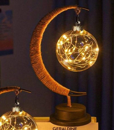 Luce decorativa a forma di luna con lampadine a filamento che creano un effetto luminoso caldo e accogliente, perfetta come decorazione scientifica o oggetto di design.