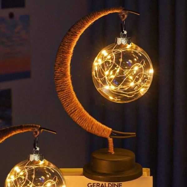 Luce decorativa a forma di luna con lampadine a filamento che creano un effetto luminoso caldo e accogliente, perfetta come decorazione scientifica o oggetto di design.