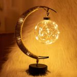Lampada decorativa a forma di luna con luce LED calda e filamenti luminosi, perfetta come oggetto scientifico e decorativo per ambienti eleganti e moderni.