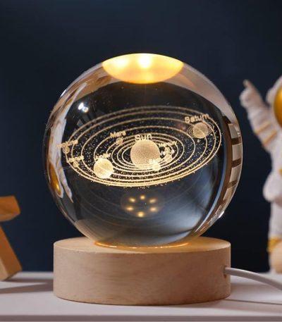 Modello del sistema solare in sfera di cristallo con pianeti e orbite dorate, su base in legno, decorazione scientifica elegante.