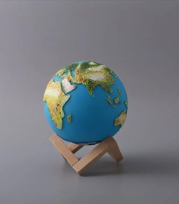Modello in miniatura della Terra su supporto di legno, rappresenta il nostro pianeta con continenti e oceani dettagliati, ideale come decorazione scientifica.