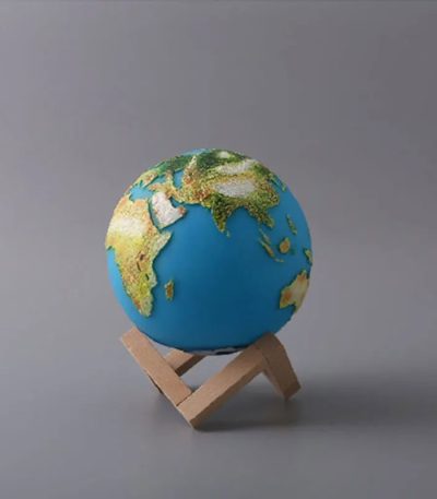 Modello in miniatura della Terra su supporto di legno, rappresenta il nostro pianeta con continenti e oceani dettagliati, ideale come decorazione scientifica.