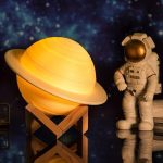 Saturno in miniatura con supporto in legno e astronauta decorativo, perfetti come oggetti scientifici e decorazioni per appassionati di spazio e astronomia.