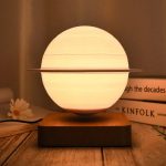 Lampada decorativa ispirata a un modello planetario, con sfera luminosa e anello orbitale, perfetta per ambienti moderni e studi scientifici.