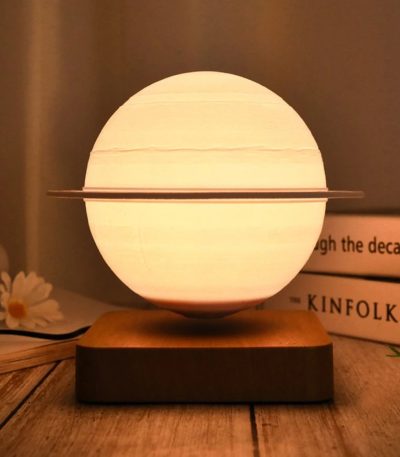 Lampada decorativa ispirata a un modello planetario, con sfera luminosa e anello orbitale, perfetta per ambienti moderni e studi scientifici.