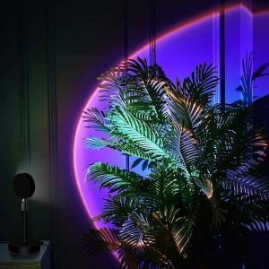Pianta tropicale decorativa con luci neon viola e arancione, ideale per ambienti moderni e creativi, creando un'atmosfera suggestiva e innovativa.