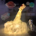 Modello di razzo con astronauti in miniatura e pianeti nello sfondo, decorazione scientifica educativa e decorativa per appassionati di spazio e scienza.