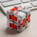 Cubo puzzle scientifico con pezzi rossi e grigi, perfetto come decorazione da scrivania o oggetto di studio per appassionati di scienza e logica.