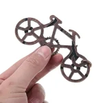Piccola decorazione in metallo a forma di bicicletta, perfetta come oggetto decorativo scientifico o da collezione, ideale per appassionati di tecnologia e design.