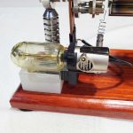 Dispositivo scientifico vintage con componenti in vetro e metallo su base di legno.