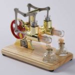 Oggetto decorativo scientifico con tubi di vetro e ingranaggi in metallo dorato, perfetto come elemento di arredo ispirato alla scienza e alla chimica.