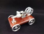 Modello di motore a vapore in miniatura con parti in metallo e base in legno, perfetto come decorazione scientifica e oggetto da collezione.