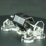 Oggetto scientifico decorativo rappresentante una piccola stazione spaziale con pannelli solari e dettagli metallici, ideale come decorazione per appassionati di scienza e tecnologia.