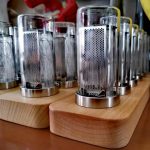Oggetti scientifici decorativi in vetro con base in legno, ideali come decorazioni per appassionati di scienza e design innovativo.