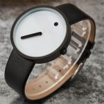 Orologio da polso con design scientifico minimalista, quadrante bianco con lancetta nera e punto nero, cinturino in pelle nera, perfetto come decorazione o oggetto da collezione scientifica.