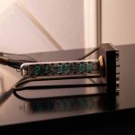 Orologio a tubo di vetro con display digitale che mostra l'ora, ideale come decorazione scientifica e oggetto di design per appassionati di scienza.