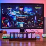Monitor con immagine di una città futuristica di notte, con luci al neon e grattacieli illuminati, creando un'atmosfera moderna e tecnologica.