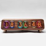 Orologio vintage con numeri LED colorati su base di legno, perfetto come decorazione scientifica e oggetto di design originale.