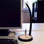 Pendo di Newton con base in legno e supporto nero, esempio di oggetto scientifico decorativo e educativo, ideale per appassionati di fisica e scienza, perfetto come decorazione da scrivania o studio.
