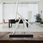 Piantana decorativa in metallo con tubi metallici disposti in modo artistico, ideale come oggetto di design e decorazione scientifica per ambienti moderni.