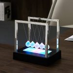 Péndolo Newton in vetro con base luminosa LED, oggetto decorativo scientifico per ufficio o studio, simbolo di fisica e scienza.