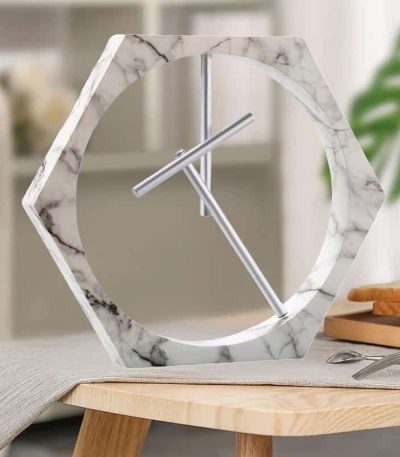 Orologio da parete decorativo in marmo con cornice a forma di esagono e lancette minimaliste, perfetto per arredare con stile moderno e scientifico.