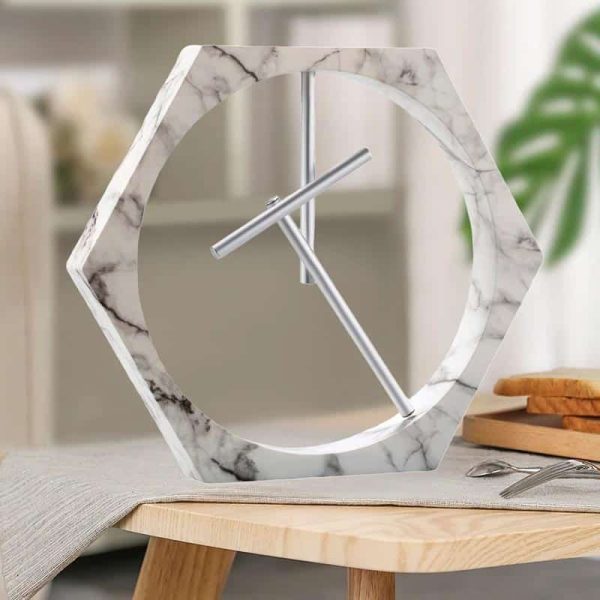 Orologio da parete decorativo in marmo con cornice a forma di esagono e lancette minimaliste, perfetto per arredare con stile moderno e scientifico.