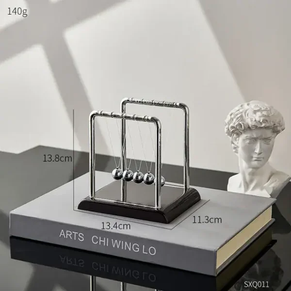 Pendolo di Newton decorativo in metallo con sfera in acciaio, perfetto come oggetto di arredamento scientifico e decorativo per scrivanie e studi.