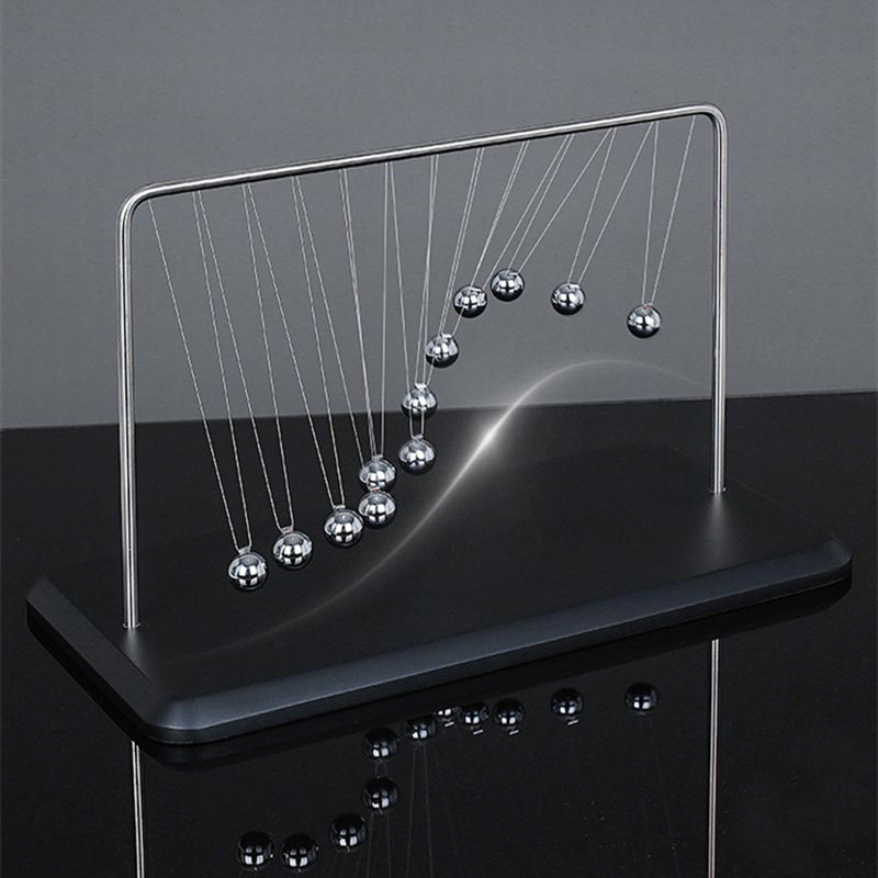 Péndolo di Newton con sfere metalliche appese a un supporto nero, illustrando il principio di conservazione dell'energia e la trasmissione delle forze.