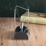 Péndolo di Newton in metallo, oggetto decorativo ispirato alla fisica, perfetto per appassionati di scienza e decorazioni originali. Un modello classico che rappresenta le leggi del movimento e la con.