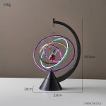 Pendolo di Newton luminoso con anelli colorati e illuminazione neon, decorazione scientifica moderna per ambienti educativi e di design.