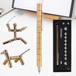 Strumenti scientifici di precisione in metallo dorato e argento, tra cui penne, sfere e componenti per esperimenti, ideali come decorazioni o oggetti da collezione.