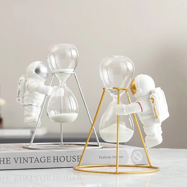 Decorazione con orologi a sabbia e astronauti in miniatura, simbolo di esplorazione e tempo, perfetta come oggetto decorativo scientifico.