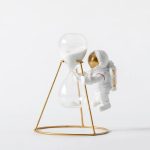 Vaso decorativo con sabbia e astronauta, simbolo di esplorazione scientifica e curiosità. Perfetto come oggetto di decorazione per appassionati di scienza e spazio.