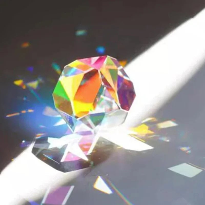 Cristallo di cristallo colorato con riflessi arcobaleno, posato su una superficie bianca con giochi di luce e riflessi. Perfetto come decorazione scientifica o oggetto da collezione.