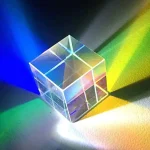 Cubo di vetro trasparente che riflette luci di vari colori, creando effetti di luce e ombra su superfici vicine. Perfetto come decorazione scientifica o oggetto da collezione.
