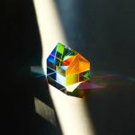 Oggetto scientifico in vetro con riflessi arcobaleno.