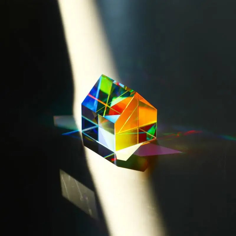 Oggetto scientifico in vetro con riflessi arcobaleno.