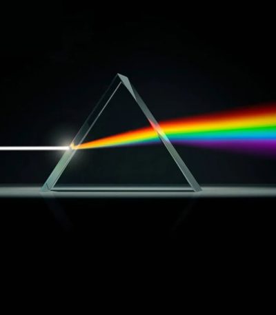 Raggio di luce bianca che attraversa un prisma, scomponendosi in uno spettro di colori vibranti.