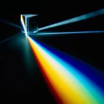 Raggio di luce che attraversa un prisma creando uno spettro di colori vibranti.