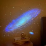Oggetto scientifico proiettato che crea un'immagine di una galassia su una parete, decorazione originale per appassionati di astronomia e scienza.