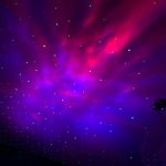 Effetto laser colorato sul soffitto, creando un'atmosfera spaziale e futuristica con punti luminosi verdi, blu e rosa.