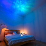 Camera da letto con pareti e soffitto illuminati da un cielo stellato luminoso, creando un'atmosfera rilassante e magica. Perfetta per gli amanti delle stelle e delle decorazioni scientifiche innovati.