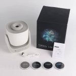 Proiettore Galaxy Lite con scatola, cavi e quattro dischi di immagini astronomiche, ideale come decorazione scientifica e oggetto di design ispirato allo spazio.