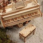 Pianoforte in legno con dettagli decorativi e sgabello abbinato, perfetti come oggetti scientifici decorativi e da collezione, realizzati in stile artigianale.