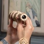 Vetrino ottico in legno con dettagli meccanici e catena decorativa, perfetto come oggetto decorativo scientifico.