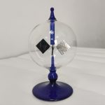Oggetto decorativo in vetro con elementi scientifici sospesi, ideale come decorazione per appassionati di scienza e design.