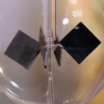 Modello di esperimento fisico con cubi di metallo sospesi in un contenitore di vetro, utilizzato per dimostrare principi scientifici di base.
