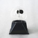 Modello di tubo di Crookes con sfera di vetro e base nera, utilizzato per esperimenti di fisica e dimostrazioni scientifiche.